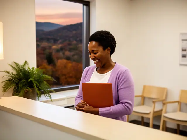 A clinic office manager holding a folder behind a reception counter.